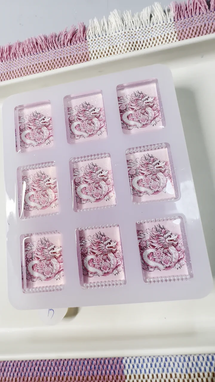 Finished handcrafted pink dragon resin American Mahjong tile backs in the production tray